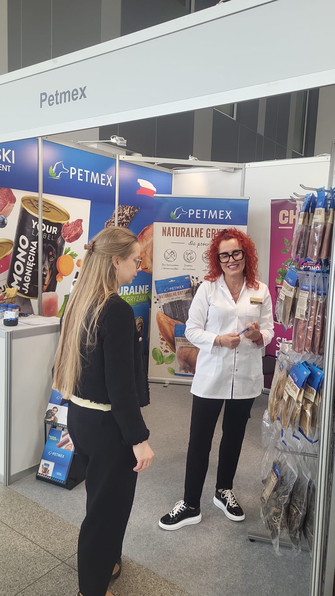 Przedstawicielka Petmex prezentuje naturalne gryzaki odwiedzającej na targach Vet Expo
